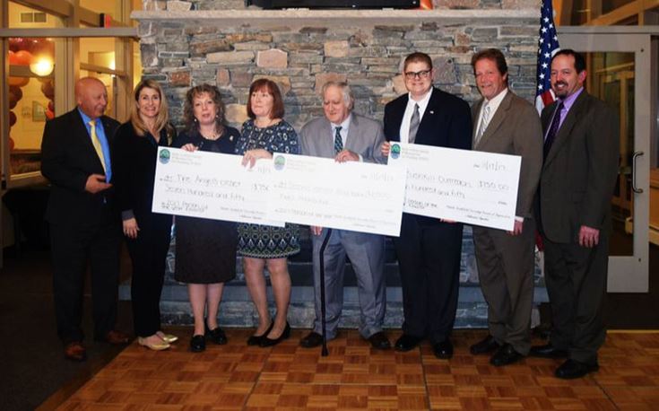 People holding oversized donation checks